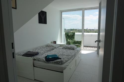 een slaapkamer met een bed en een groot raam bij Augartenblick Penthauscombo 15/16 - Blick zum Riesenrad in Wenen