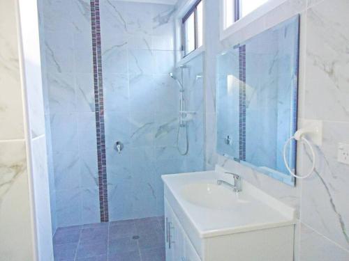 uma casa de banho com um lavatório e uma cabina de duche em vidro. em CHAP14C - Chapman Cottage em Myola