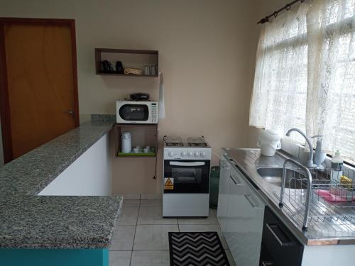 a small kitchen with a stove and a sink at Residencial Joed 4 in Dourados