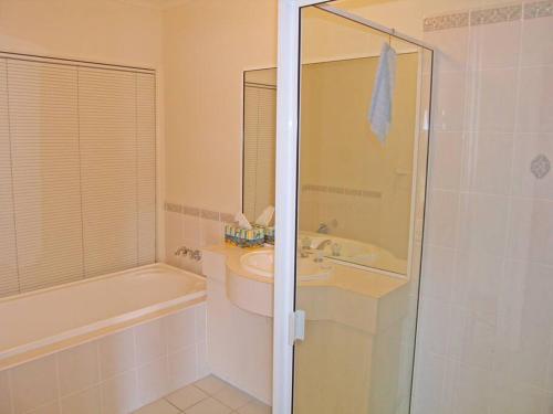 een badkamer met een bad, een wastafel en een douche bij ORSO1O - Water View House in Greenwell Point