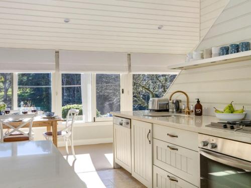 a kitchen with white cabinets and a table and some windows at Protestant Hall in Wildes Meadow