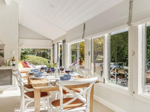 a dining room with a table and chairs and windows at Protestant Hall in Wildes Meadow