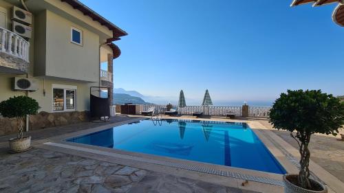 a swimming pool in front of a building at Уютная вилла с шикарным панорамным видом in Alanya
