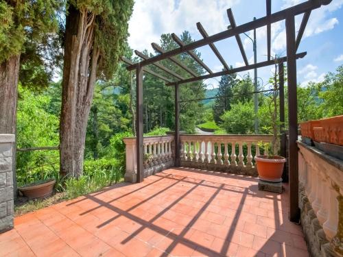 a wooden pergola on a patio with trees at Belvilla by OYO Villa Cerignano in Fivizzano