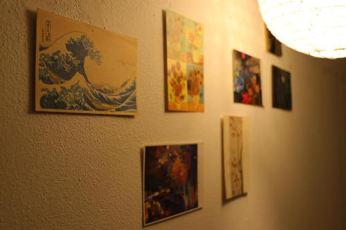 a bunch of pictures hanging on a wall at Shanti House Sakaiminato in Sakaiminato