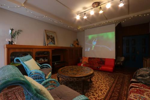 a living room with couches and a projection screen at Shanti House Sakaiminato in Sakaiminato