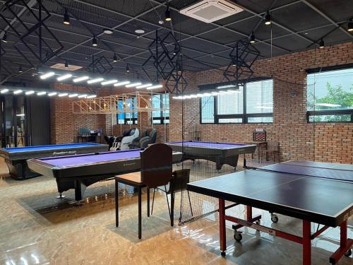 una sala de ping pong con varias mesas y pelotas de ping pong en Hotel Quatz en Busan