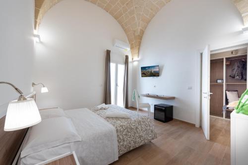 una camera bianca con letto e scrivania di Dimora Le Volte a Lecce