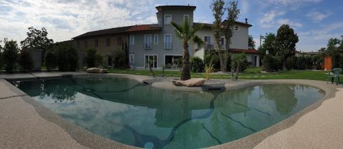a house with a swimming pool in front of a house at Gruppo Luxe Domus Vigevano in Vigevano