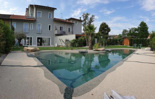 a swimming pool in front of a house at Gruppo Luxe Domus Vigevano in Vigevano