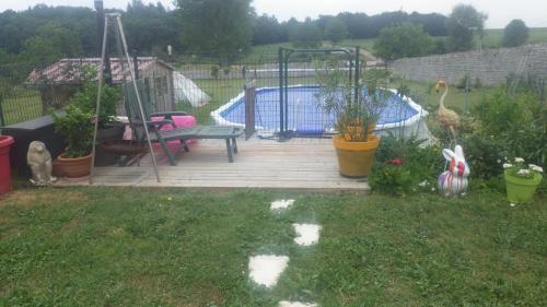 a backyard with a deck with a swimming pool at Le Logis du Bouil in Champagne
