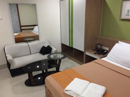 a hotel room with a bed and a chair at RedDoorz Plus @ ABC Landmark Hotel in Kidapawan