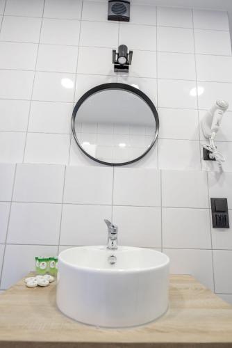 a bathroom with a white sink and a mirror at Apartamenty Pawełek in Zator