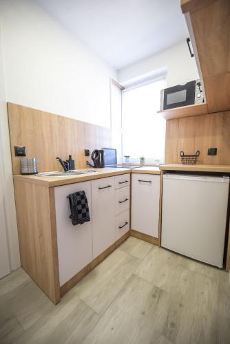 a kitchen with white cabinets and a sink at Apartamenty Pawełek in Zator