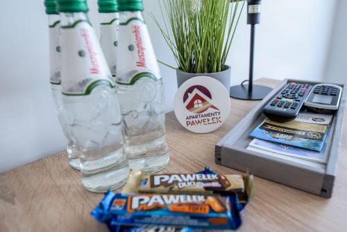 a table with a bottle of water and some snacks at Apartamenty Pawełek in Zator