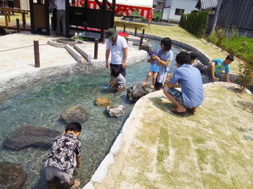 a group of children playing in a pool of water at Racine Home Harie in Takashima