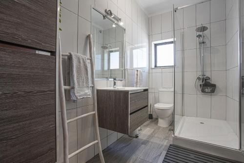 ein Bad mit einer Dusche, einem Waschbecken und einem WC in der Unterkunft Villa Casa Rosina in Ferragudo
