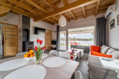 a kitchen and living room with a table and chairs at Kolory Mazur in Stare Jabłonki