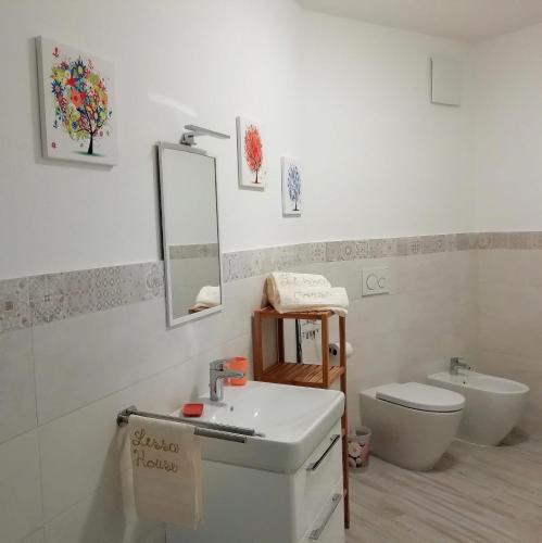 a bathroom with a sink and a toilet and a mirror at LissaHouse Agriturismo in San Pietro Vara