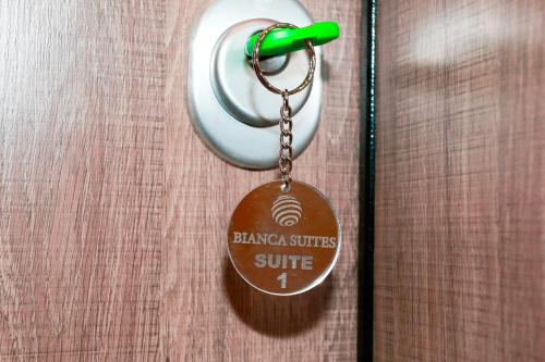 a key chain with a sign on a door at Bianca Suites in Nea Moudania
