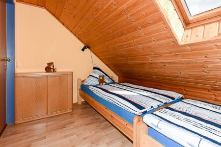 a bed in a room with a wooden ceiling at Ferienwohnung Christophers in Stedesdorf