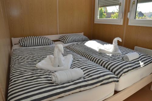 two beds with swans on them in a room at Počitniške hiške Murania in Trimlini