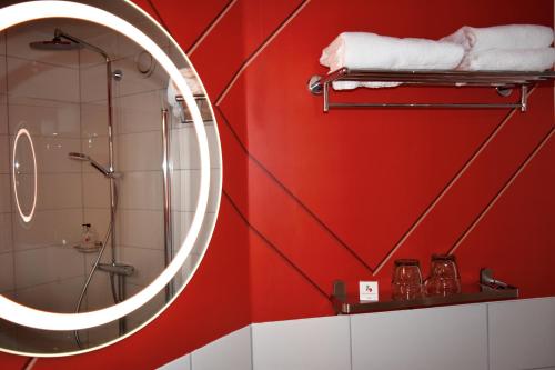 a bathroom with red walls and a shower with a mirror at Good Morning Mölndal in Mölndal