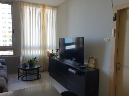 a living room with a large flat screen tv at Sea View Deluxe in Bat Yam