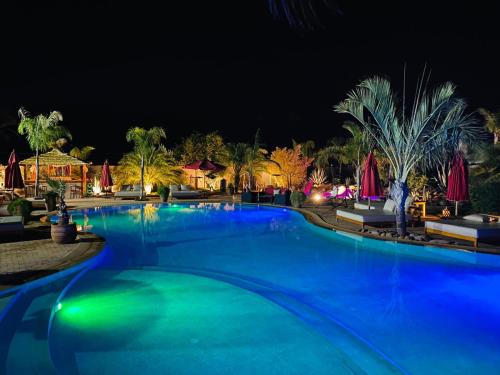 - une piscine éclairée en bleu la nuit dans l'établissement Eden Lodges & SPA, à Marrakech