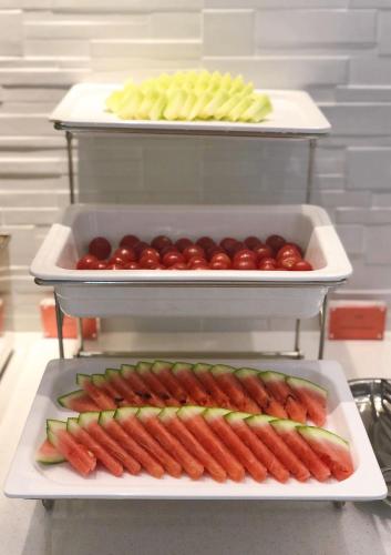 a tray of hot dogs and tomatoes on a table at Shanghai JOYFUL YARD Hotel-Free shuttle bus to Pudong Airport and Disneyland in Shanghai