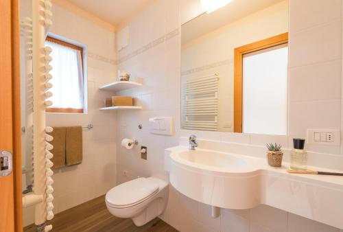 biała łazienka z umywalką i toaletą w obiekcie Appartment Pircher 3 w mieście Siusi