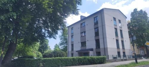 a tall white building next to a street at APARTAMENTY ZDROJOWA 9 in Duszniki Zdrój