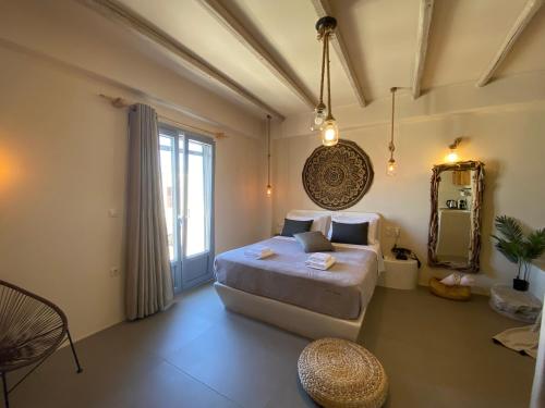 a bedroom with a large bed and a mirror at Ampelos Suites in Naxos Chora