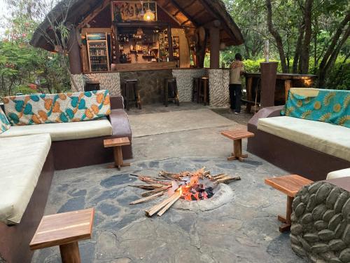 a patio with a fire pit and a bar at Camp Bastian Mikumi in Mikumi
