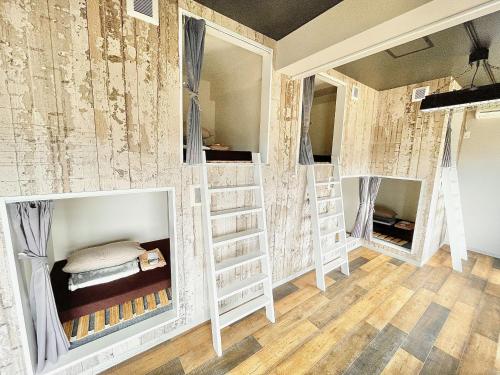 a room with bunk beds in it with a wall covered in wallpaper at Book Tea Bed IZUOSHIMA in Oshima