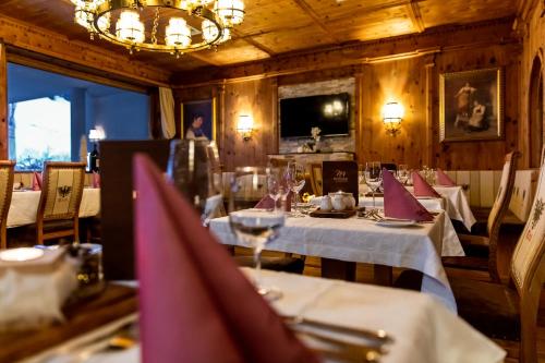 a dining room with tables and chairs and a chandelier at Mallaun Hotel.Erlebnis in See