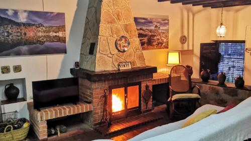 - un salon avec une cheminée et un canapé dans l'établissement Casa independiente y completa con una habitación "Venta de Cidones", à Cidones