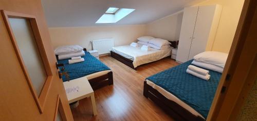 Cette petite chambre comprend deux lits et une lucarne. dans l'établissement Gościnna Arkada, à Kleszczele