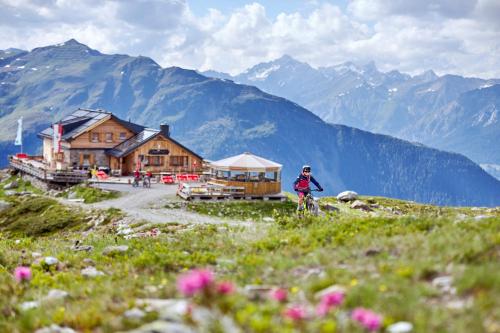a person riding a bike on a hill with mountains at Mallaun Hotel.Erlebnis in See