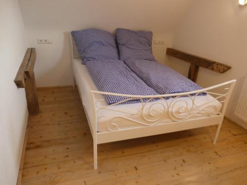 een wit bed met twee blauwe kussens erop bij s' Moose Hof in Weisweil