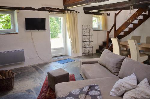 a living room with a couch and a tv at Lodge Kervoazec - Château de Kervoazec in Saint-Goazec