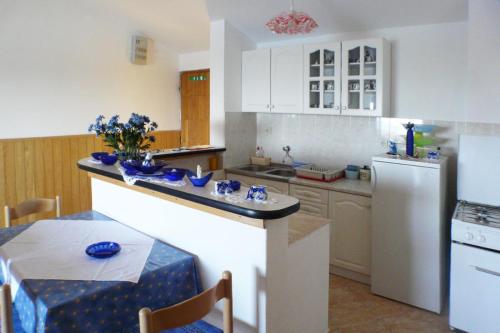 kuchnia ze stołem i białą lodówką w obiekcie A2 - apt near beach with terrace and the sea view w mieście Blato
