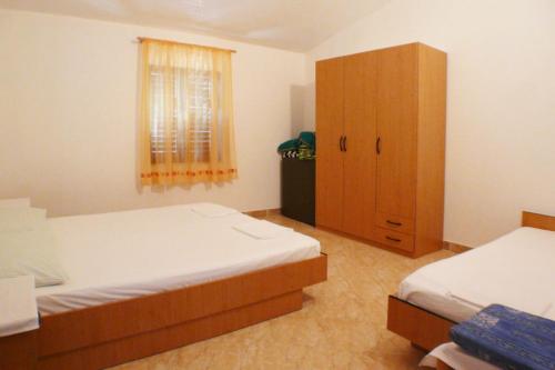 - une chambre avec 2 lits et une armoire en bois dans l'établissement A2 - apt near beach with terrace and the sea view, à Blato