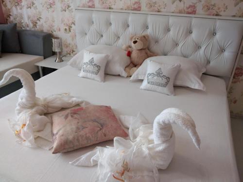 a bed with swans and a teddy bear on it at Къща за гости Синьо Лято in Pomorie
