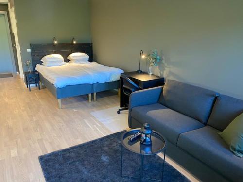 a living room with a couch and a bed at Magnolia House Norrviken in Sollentuna