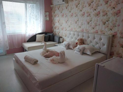 three dolls laying on a bed in a bedroom at Къща за гости Синьо Лято in Pomorie