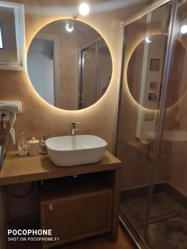 a bathroom with a sink and a shower with a mirror at Momentum Θ in Maleme