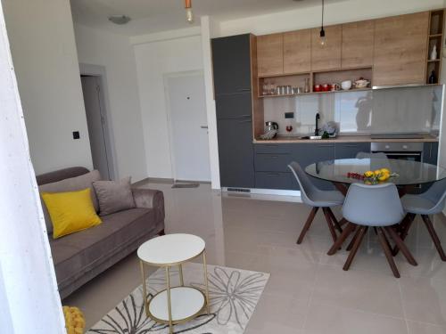 una sala de estar con un sofá y una mesa en apartman_maree, en Herceg-Novi