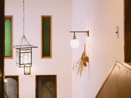 a wall with different types of windows and a light fixture at Guesthouse Hitoyado in Shizuoka
