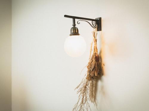 a light bulb hanging on a wall at Guesthouse Hitoyado in Shizuoka